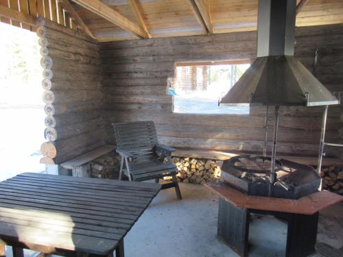 a room with a stove and a table and a chair at Mäkitorppa in Varpaisjärvi