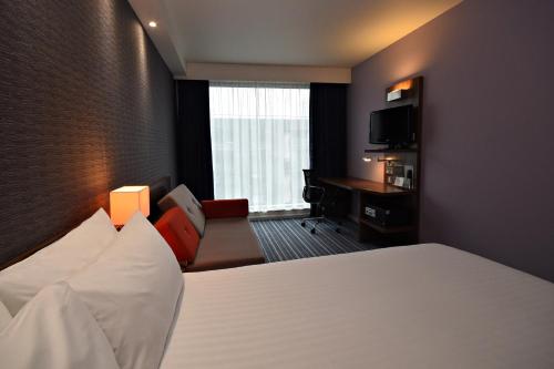 a hotel room with a bed and a desk at Holiday Inn Express Manchester City Centre Arena by IHG in Manchester