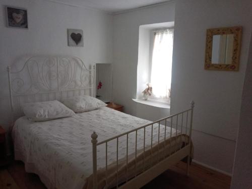 um quarto com uma cama branca e uma janela em Peggy em Cotignac