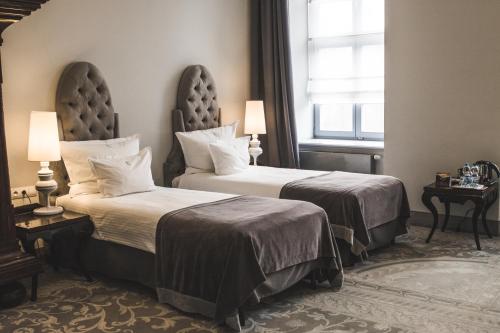a hotel room with two beds and a window at Hotel Krasicki in Lidzbark Warmiński
