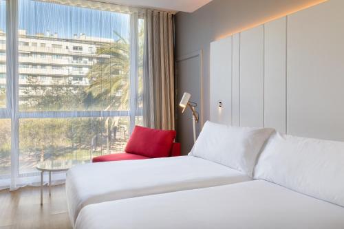 a hotel room with a bed and a window at Occidental Atenea Mar - Adults Only in Barcelona