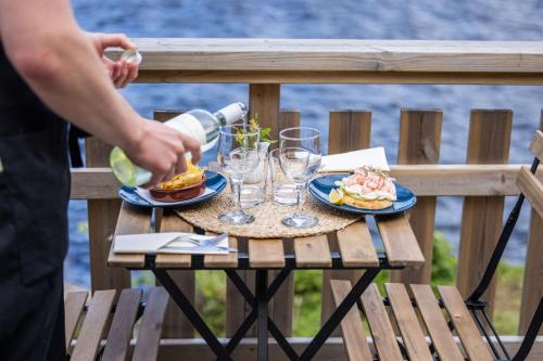 RamvikにあるSnibben Höga Kustenのテーブル(2皿の食べ物とワイングラス付)