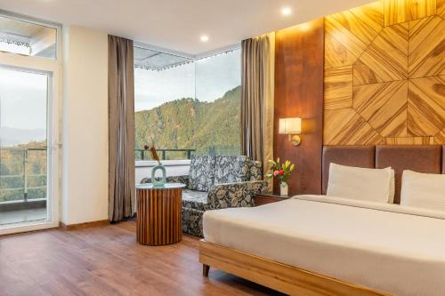 a bedroom with a bed and a chair and a window at Country Inn Premier Pacific Mall Road Mussoorie in Mussoorie
