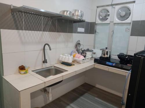 a small kitchen with a sink and a stove at Muslim Homestay blue Adik Aisyah Apartment in Tanah Rata
