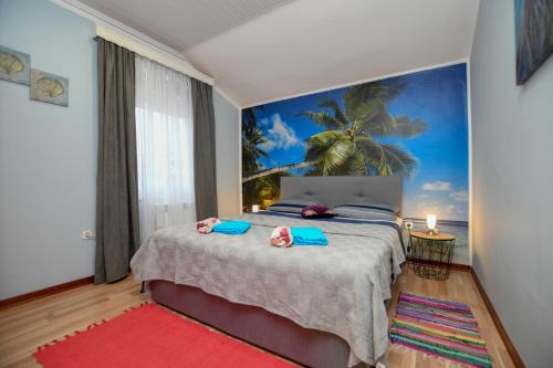 een slaapkamer met een groot bed met een muurschildering van palmbomen bij Apartments Katja in Poreč