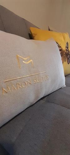 a pillow on a bed with the name maroon suites at MARON in Kalavrita