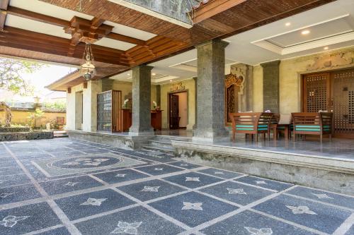 an outdoor patio with a table and chairs at Starloka Saba Bali Hotel in Blahbatu