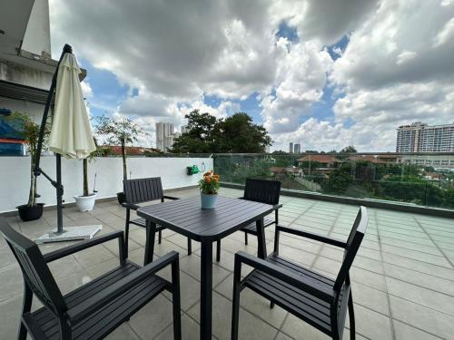 a table and chairs on a balcony with an umbrella at Paragon Residence 8-12pax-Big Balcony with BBQ in Johor Bahru