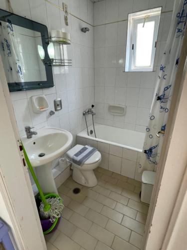 a bathroom with a sink and a toilet and a tub at Doreen Suites in Kalamaki