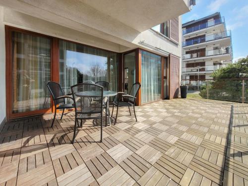 a patio with a table and chairs on a balcony at Apartamenty Na Wyspie - Baltic Park - Apartamenty z sypialnią i parkingiem - ul Uzdrowiskowa 24-34 in Świnoujście