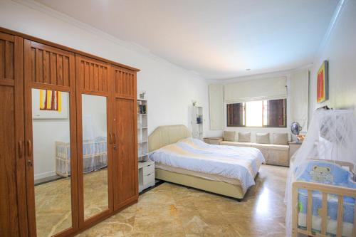 ホアヒンにあるLaguna Villa 2のベッドルーム1室(ベッド1台付)、大きな木製キャビネットが備わります。
