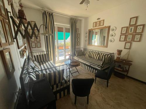 a living room with striped couches and a window at ALLOGGIO VISTA MARE LOANO in Loano