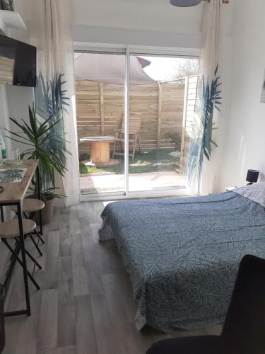 a bedroom with a bed and a large window at Chez Flo&Fred in Barbery