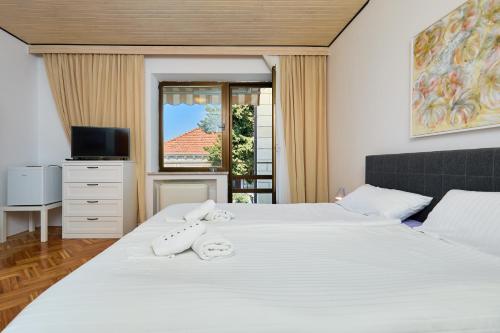 sypialnia z 2 łóżkami z białą pościelą i oknem w obiekcie DUBROVNIK HAUS suites w Dubrowniku
