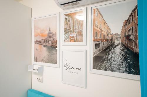 a wall with three pictures of a canal at Апартаменти MYFREEDOM поруч із метро Чернігівська in Kyiv