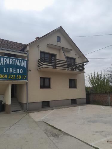 a house with a sign in front of it at LIBERO APARTMANI in Surčin