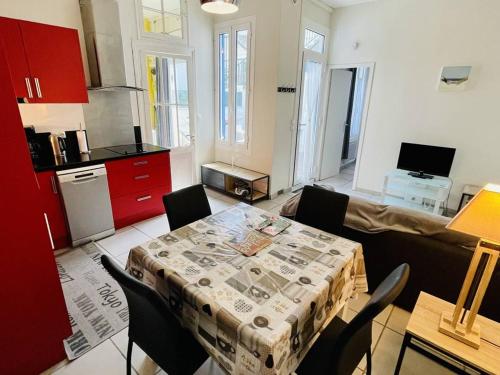 un salon avec une table et une cuisine dans l'établissement Élégante maisonnette à 230m de la plage avec terrasse, clim, WiFi - idéale 5 pers., Arcachon - FR-1-433-100, à Arcachon