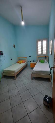 Habitación con 2 camas y pared azul en Casa Orosei Mannu, en Orosei