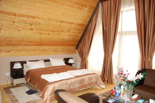 a bedroom with a bed and a wooden ceiling at Qusar Olimpik Hotel and Cottages in Qusar