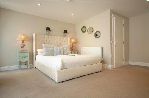 a bedroom with a large white bed and two lamps at Molesworth Arms in Wadebridge