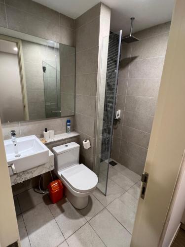 y baño con aseo, lavabo y ducha. en OOAK residence, en Kuala Lumpur