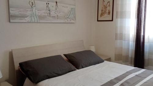 uma cama com duas almofadas num quarto em Savonamare em Savona