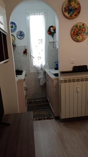 eine Küche mit einem Fenster und eine Treppe, die in eine Küche führt in der Unterkunft Savonamare in Savona