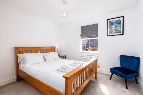 um quarto com uma cama e uma cadeira azul em Beautiful Big Family Home - Sleeps 10, Park 3 Cars em Meanwood