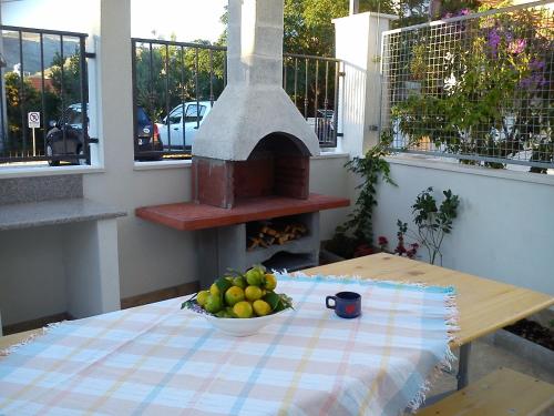 a table with a bowl of fruit on a table with a oven at Apartment Gabre Trogir in Trogir