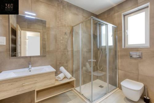 a bathroom with a shower and a sink and a toilet at Stunning 3BR penthouse, opposite the harbour by 360 Estates in Tal-Pietà