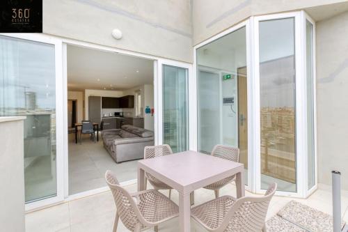 een woonkamer met een tafel en stoelen bij Stunning 3BR penthouse, opposite the harbour by 360 Estates in Tal-Pietà