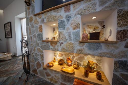 a room with a stone wall with a fireplace at Bujtina GleAlb in Tepelenë