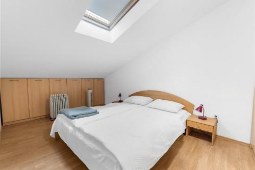 um quarto com uma grande cama branca e uma clarabóia em Apartment Luna em Porec