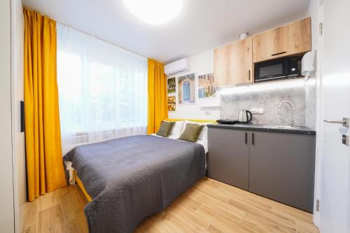 a small bedroom with a bed and a kitchen at Апартаменти MYFREEDOM поруч із метро Чернігівська in Kyiv