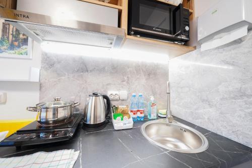 a kitchen counter with a sink and a microwave at Апартаменти MYFREEDOM поруч із метро Чернігівська in Kyiv
