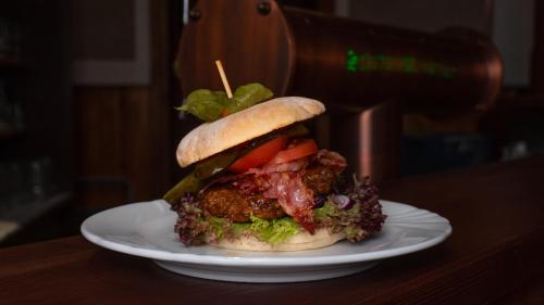 a sandwich on a white plate on a table at Pension Schrammsteinbaude in Bad Schandau