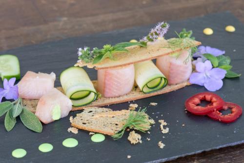 a sandwich with meat and vegetables on a black plate at Hotel Sternen in Buochs