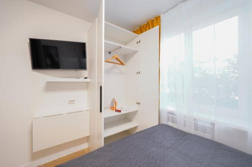 a bedroom with white walls and a tv and a window at Апартаменти MYFREEDOM поруч із метро Чернігівська in Kyiv