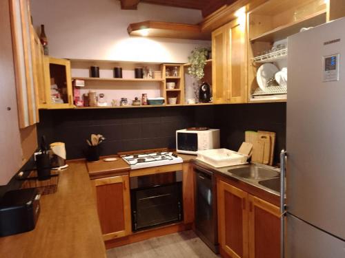 a kitchen with a refrigerator and a stove top oven at Dom leśny w Konarzynach in Stara Kiszewa