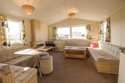 ein Wohnzimmer mit einem Sofa und einem Tisch in der Unterkunft Superb 6 Berth, Dog Friendly Caravan For Hire By The Beach In Norfolk Ref 50008m in Great Yarmouth