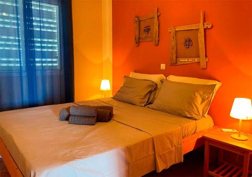 a bedroom with orange walls and a bed with two lamps at Appartamento Garroupa. Stella Maris Exclusive in Vila do Porto