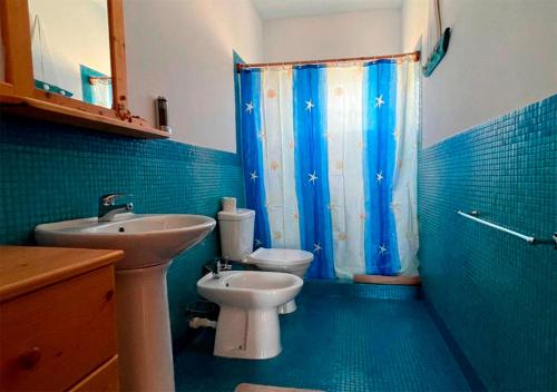 a blue bathroom with a sink and a toilet at Appartamento Garroupa. Stella Maris Exclusive in Vila do Porto