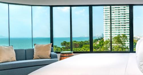 a bedroom with a bed and a couch and ocean views at Ocean Marina Resort Pattaya Jomtien in Na Jomtien