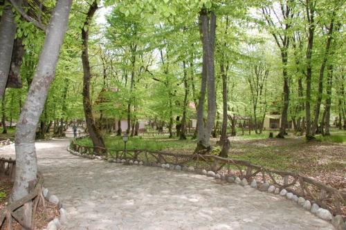a wooden fence in a park with trees at Arena Hotel Gusar in Qusar