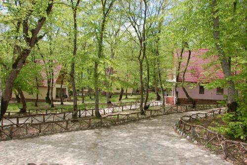 a path in a park with trees and a fence at Arena Hotel Gusar in Qusar