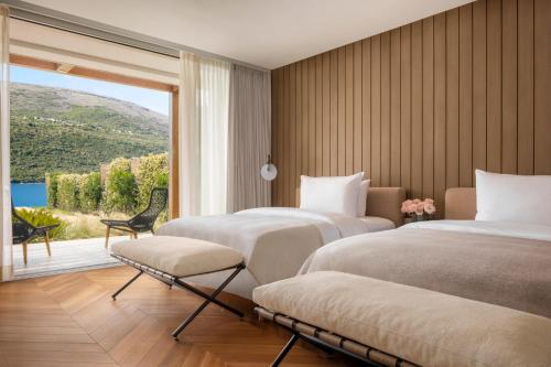 a hotel room with two beds and a large window at One&Only Portonovi in Herceg-Novi