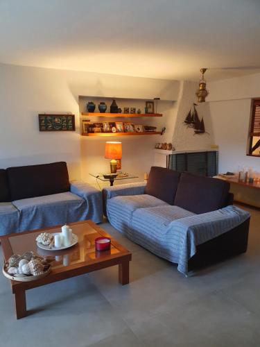 una sala de estar con 2 sofás azules y una mesa. en POROS Summer Apartment - Neorio, en Poros