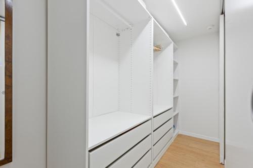 a walk in closet with white walls and white cabinets at La Corte Apartment 1 in Peschiera Borromeo