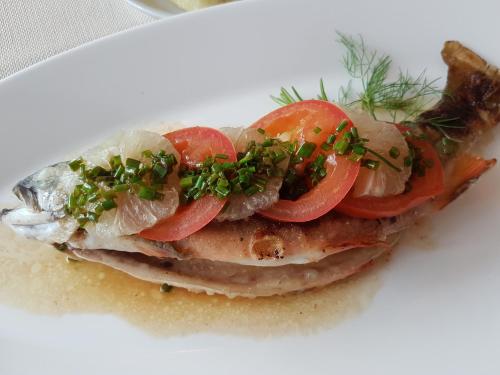 a sandwich with fish and tomatoes on a white plate at Hotel Sternen in Buochs