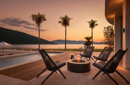 a patio with chairs and a table and a pool at One&Only Portonovi in Herceg-Novi